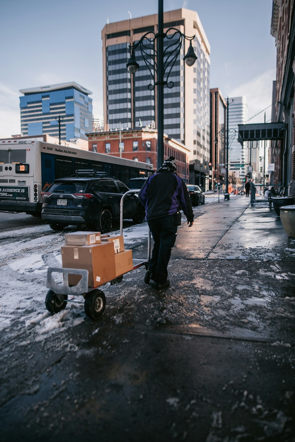 a man pushing a cart down a city street