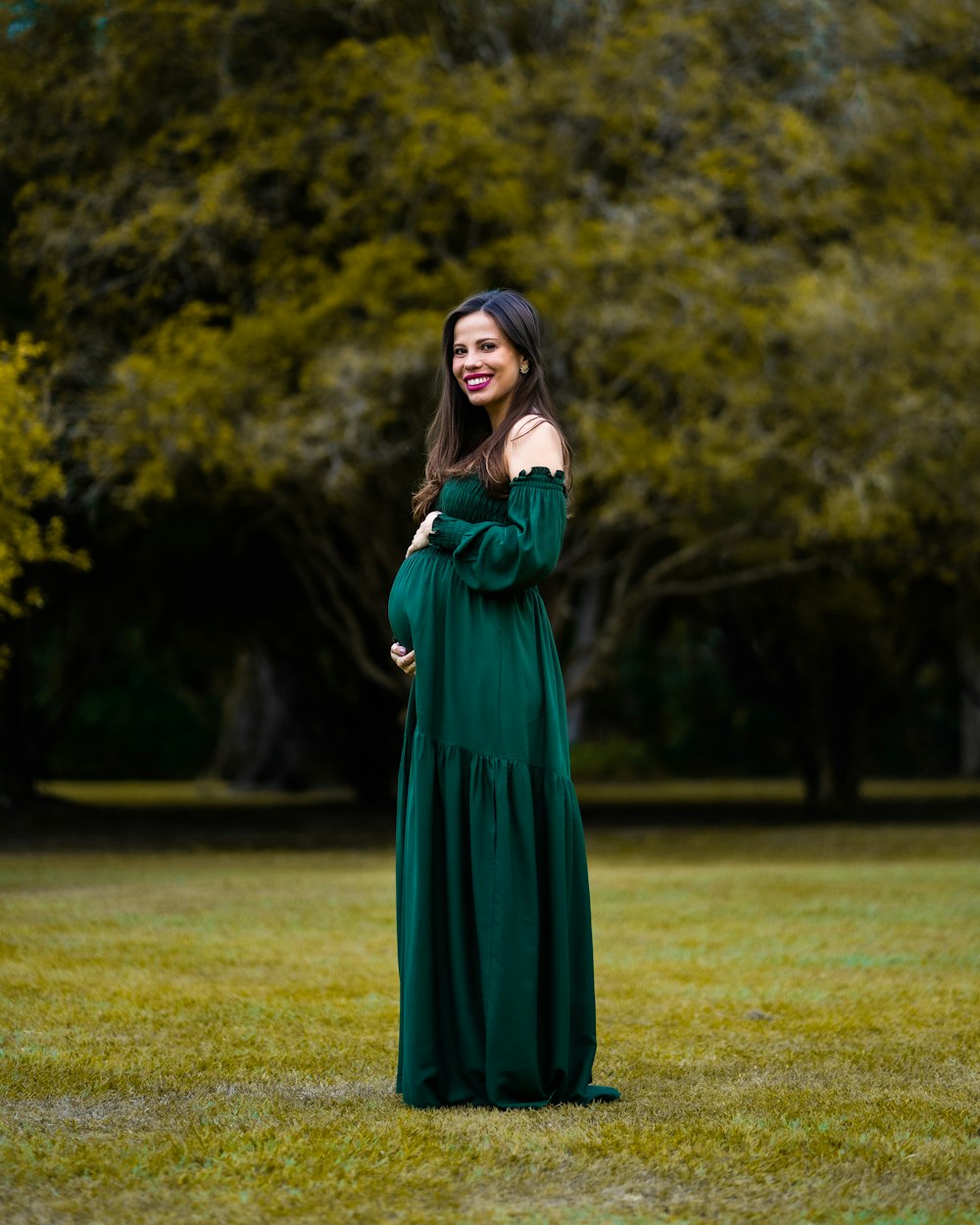 a woman in a green dress standing in a field