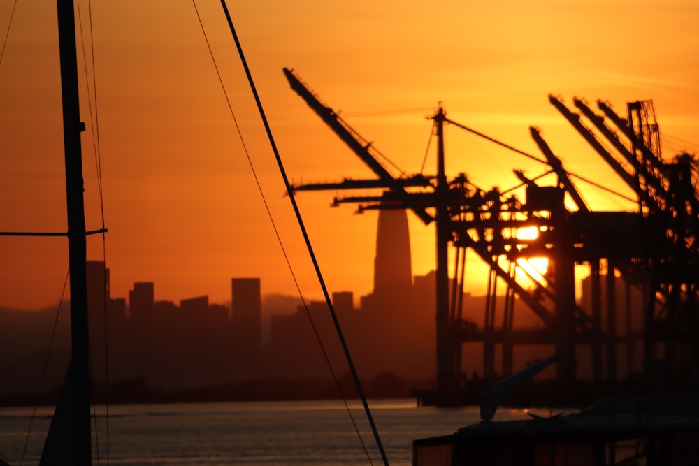 the sun is setting over a harbor with sailboats