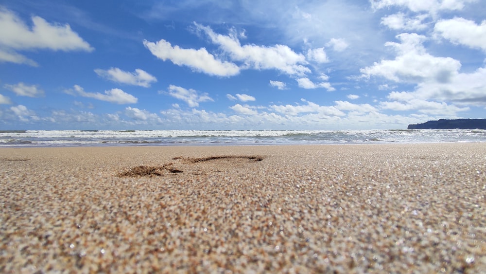 a sandy beach with waves coming in to shore