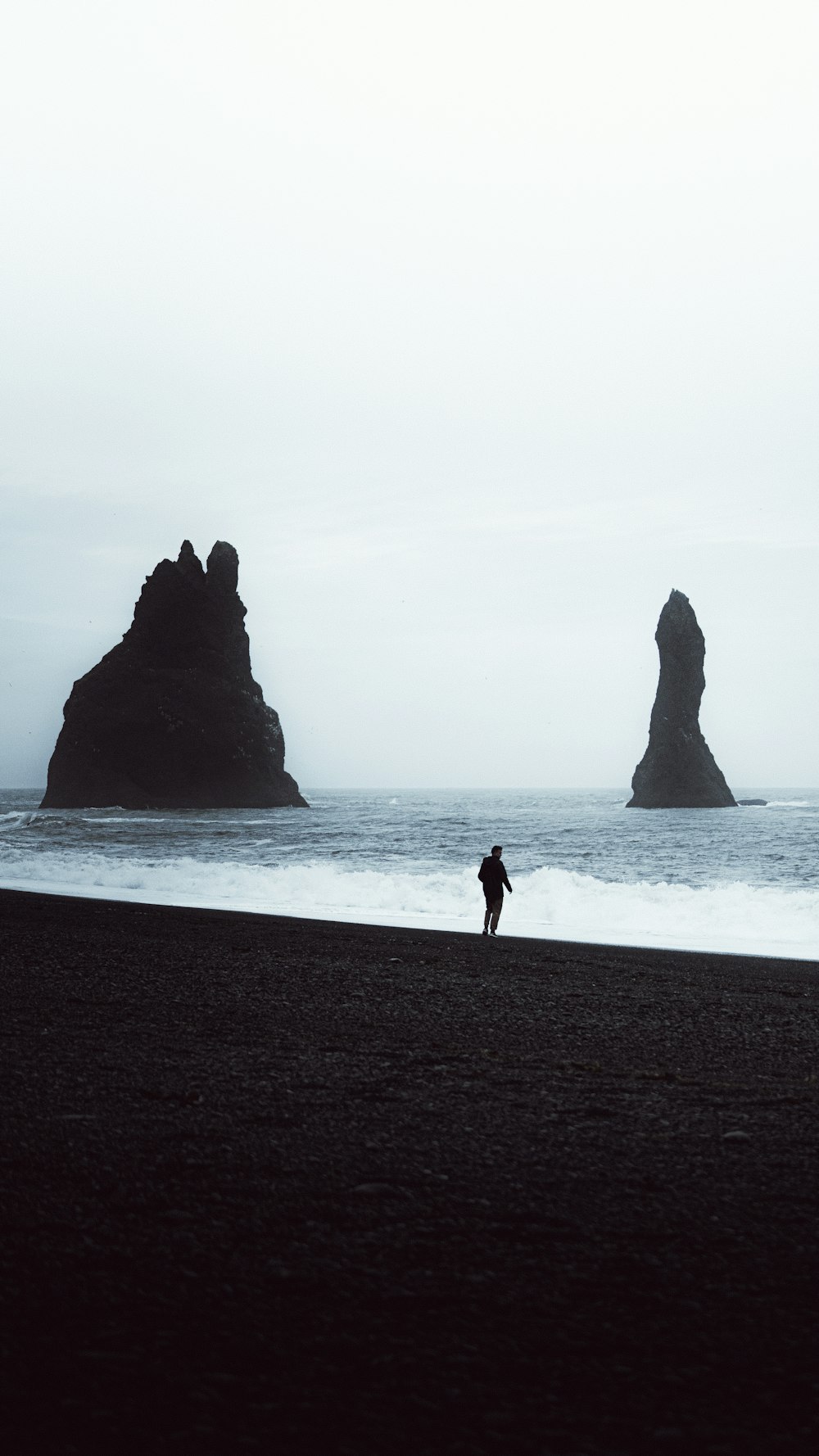 a person standing on a beach next to the ocean