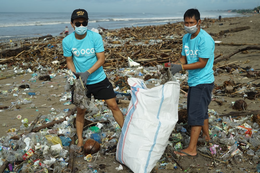 a couple of people standing on top of a pile of trash