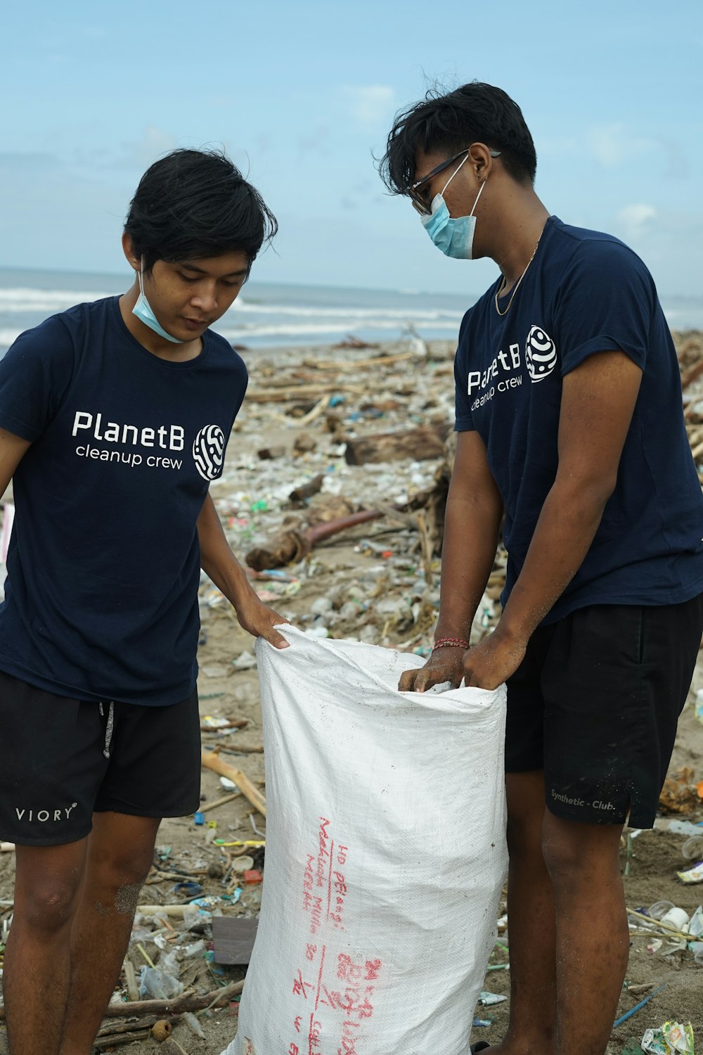 a couple of men standing next to a pile of trash