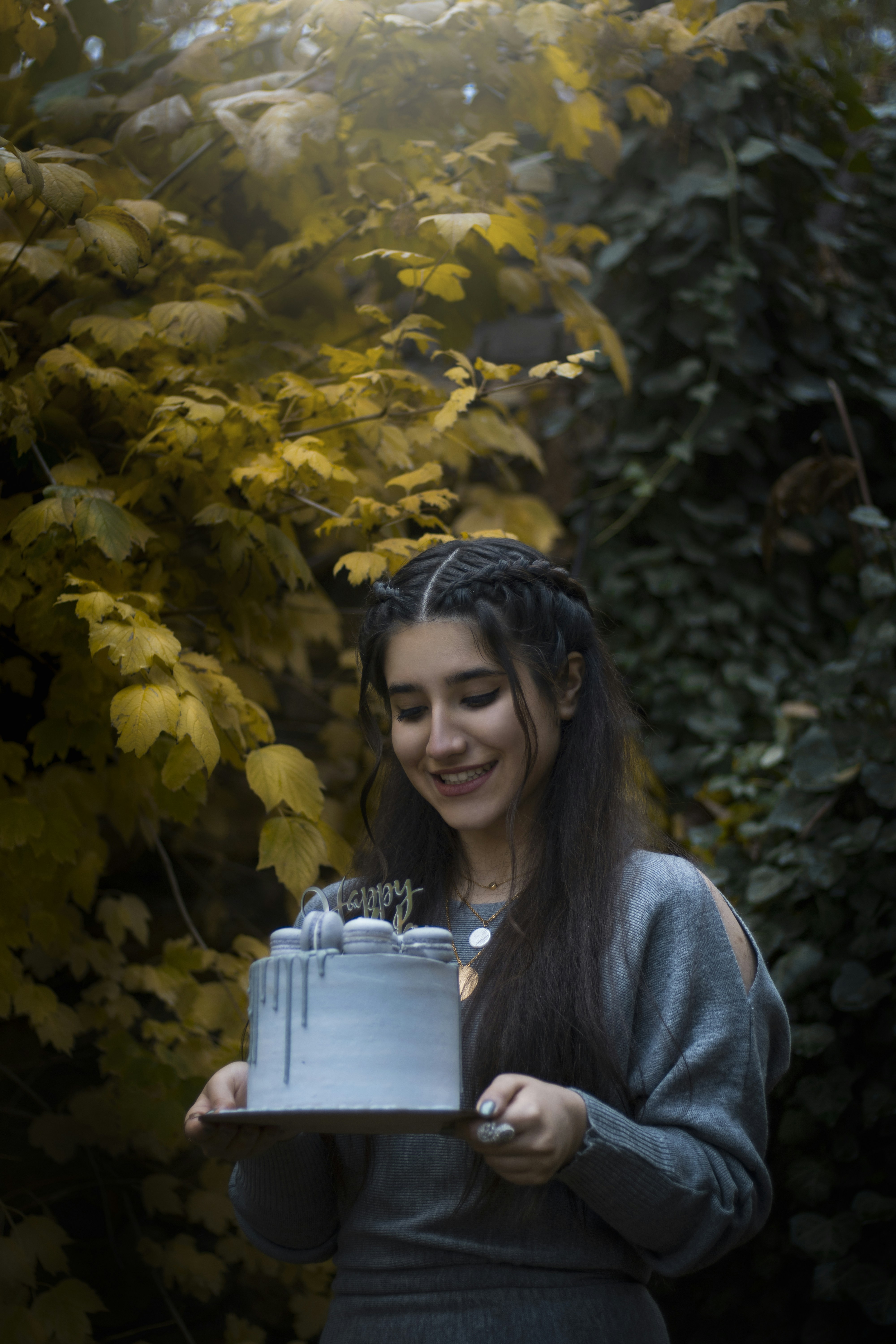 a woman holding a cake with candles on it