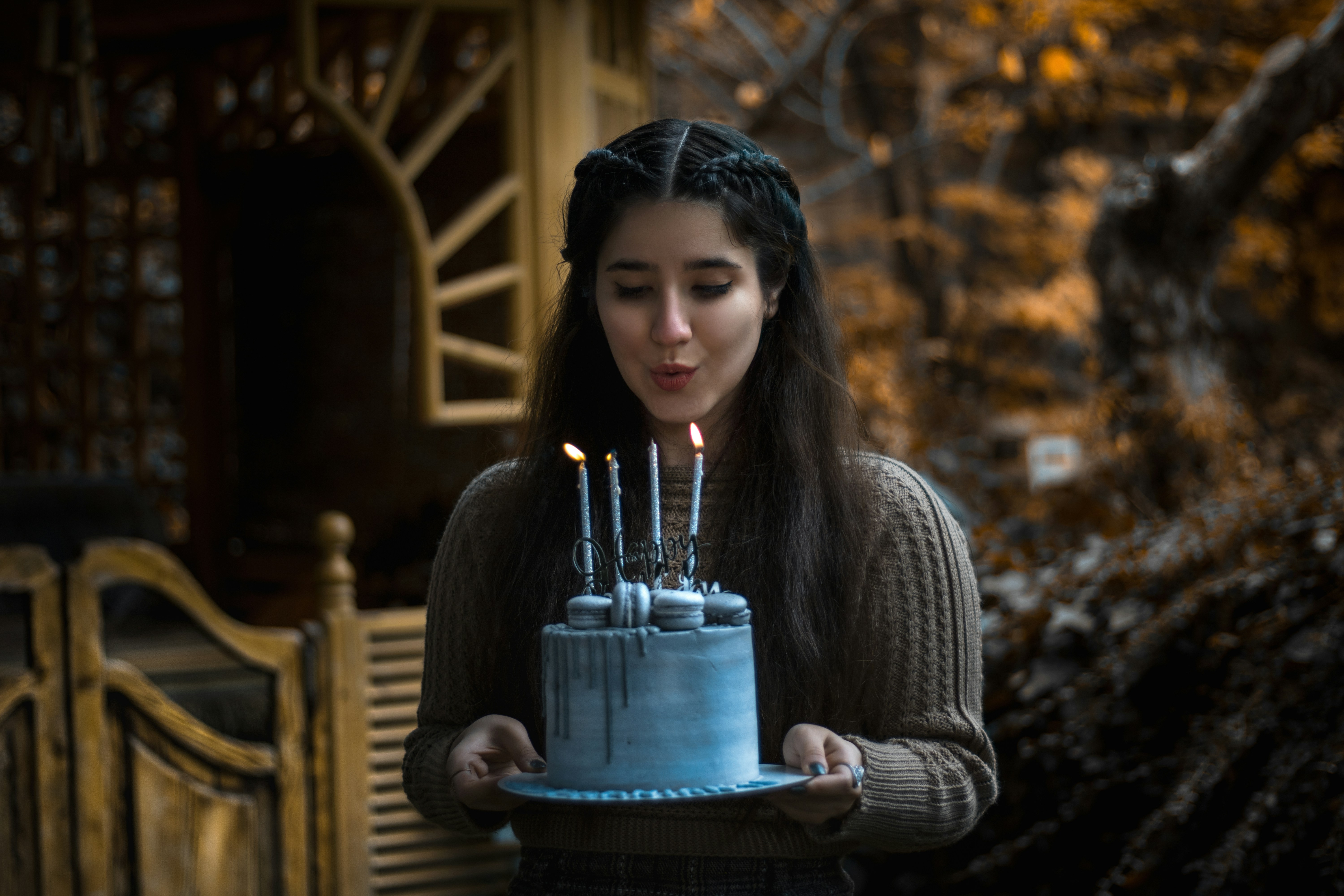 a woman holding a cake with lit candles