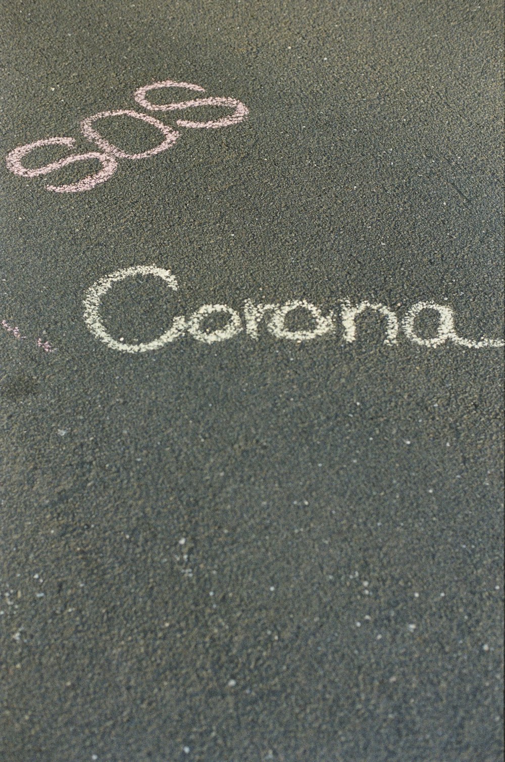 a close up of a bus stop sign with the word corona written in chalk