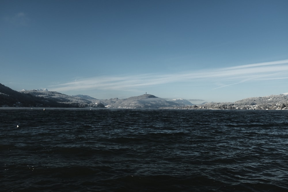 a body of water with mountains in the background