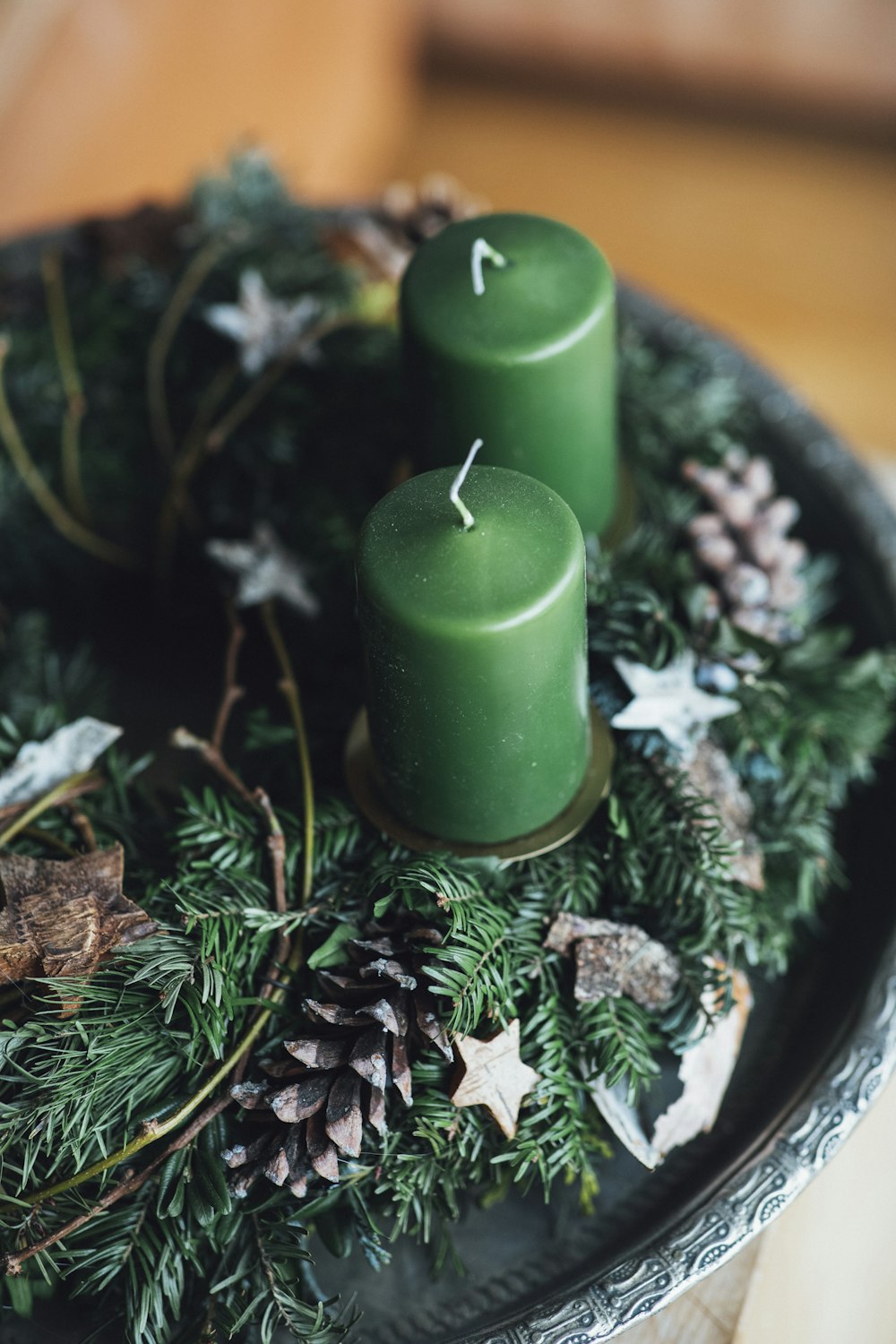 two green candles sitting on top of a tray