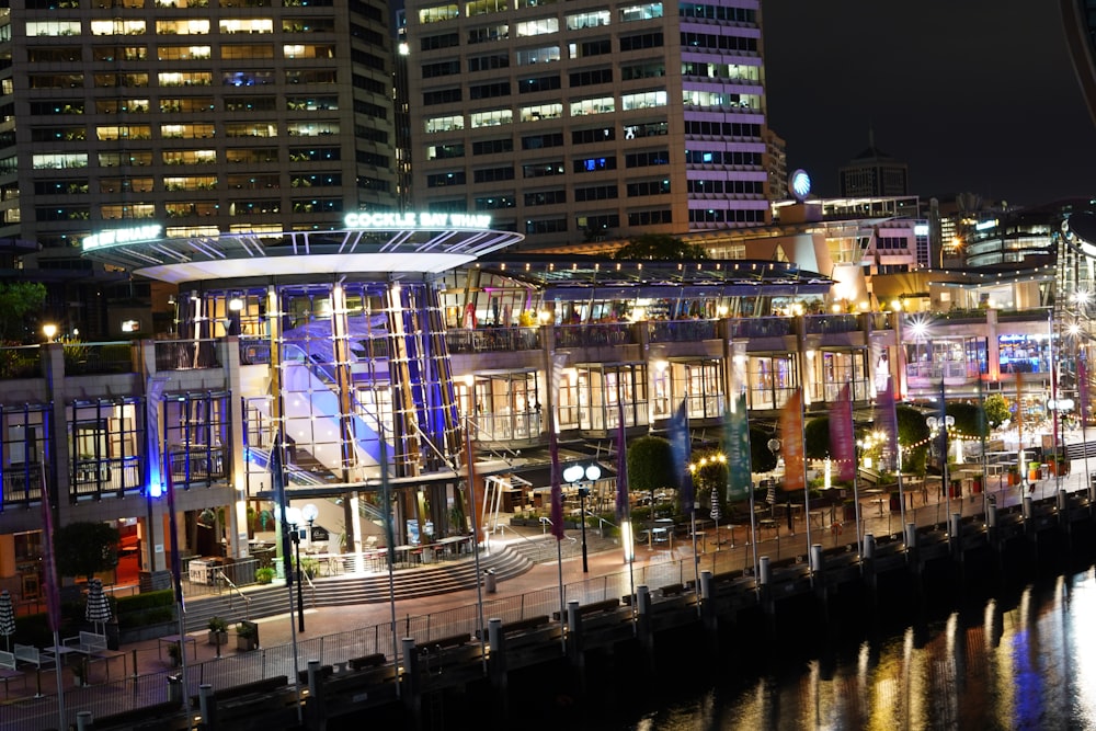 a city at night with tall buildings and a river