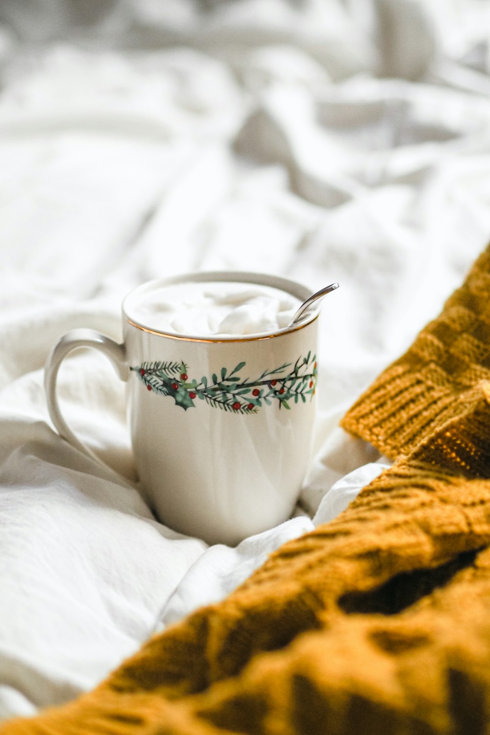 a cup of coffee sitting on top of a bed