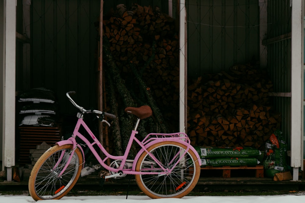 Una bicicleta rosa estacionada frente a un edificio