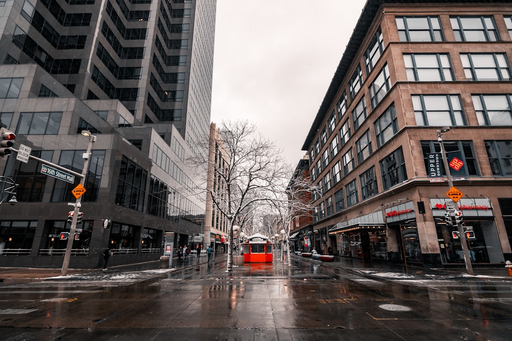 a wet city street with buildings and traffic lights