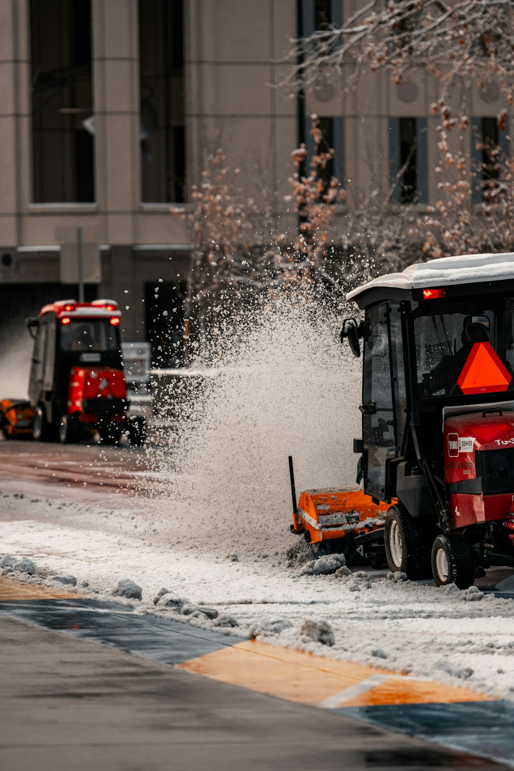 a street sweeper cleaning snow from the sidewalk