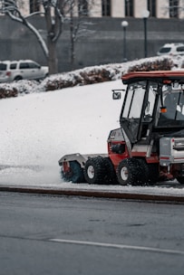 a tractor is plowing snow on a city street