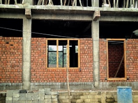 a red brick building with a blue trash can in front of it