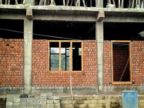 a red brick building with a blue trash can in front of it