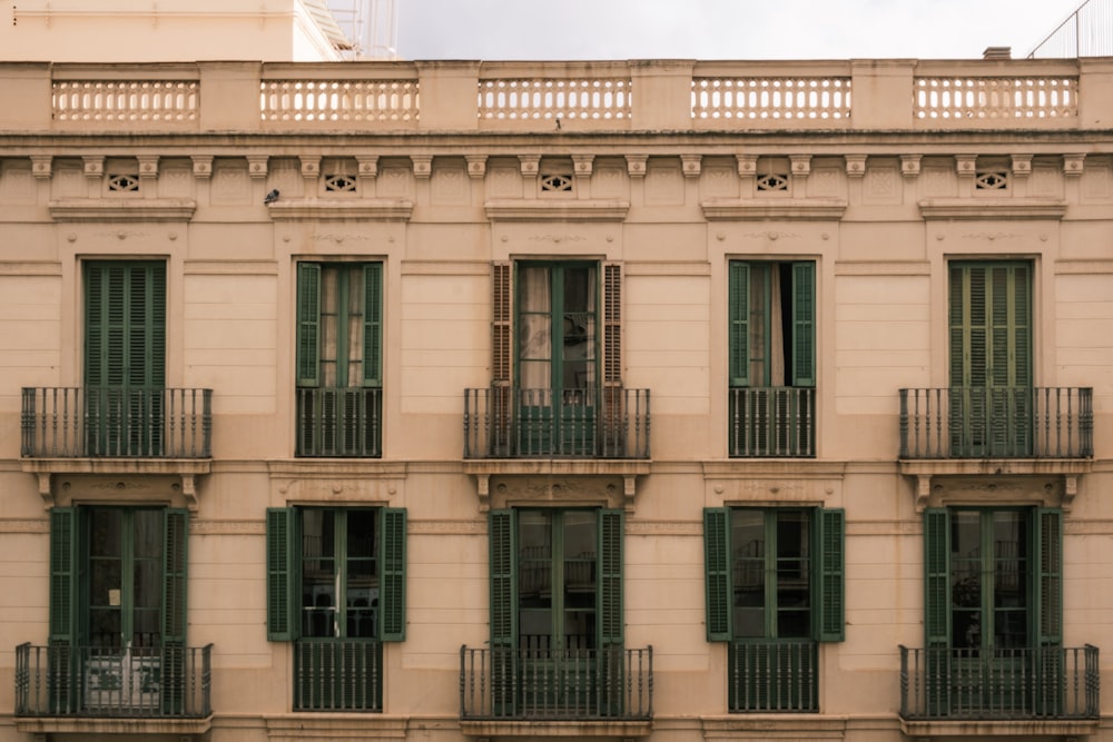 a building with green shutters and balconies