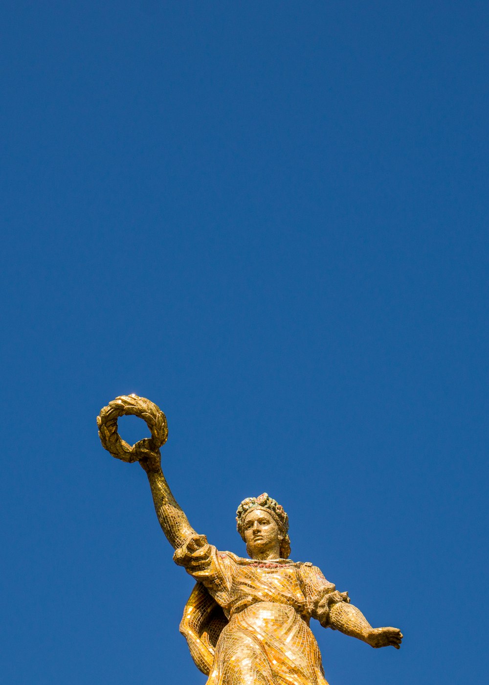 a statue of a woman holding a ring on top of a building