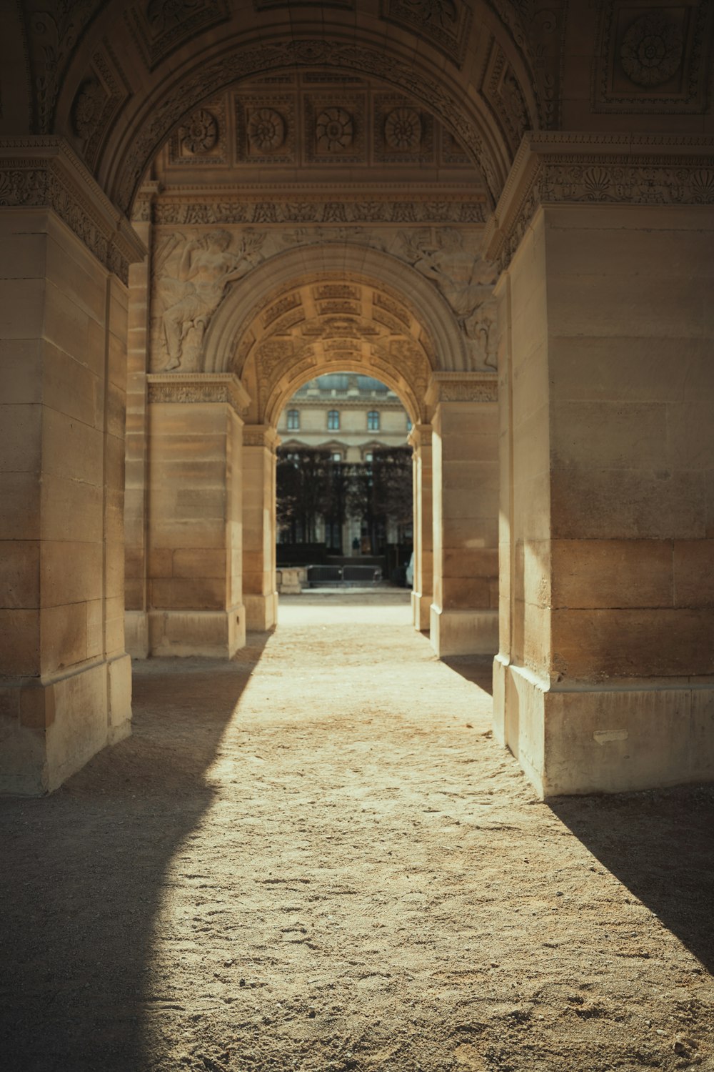 an archway leading to a building with a clock on it