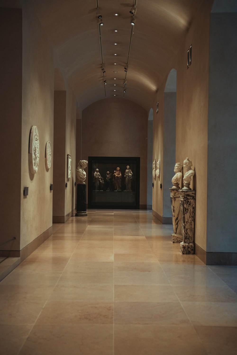 a long hallway with sculptures on either side of it