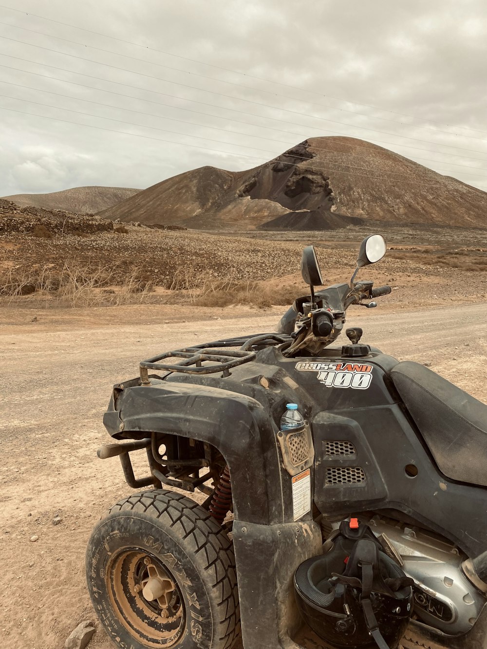 a motorcycle parked on the side of a dirt road