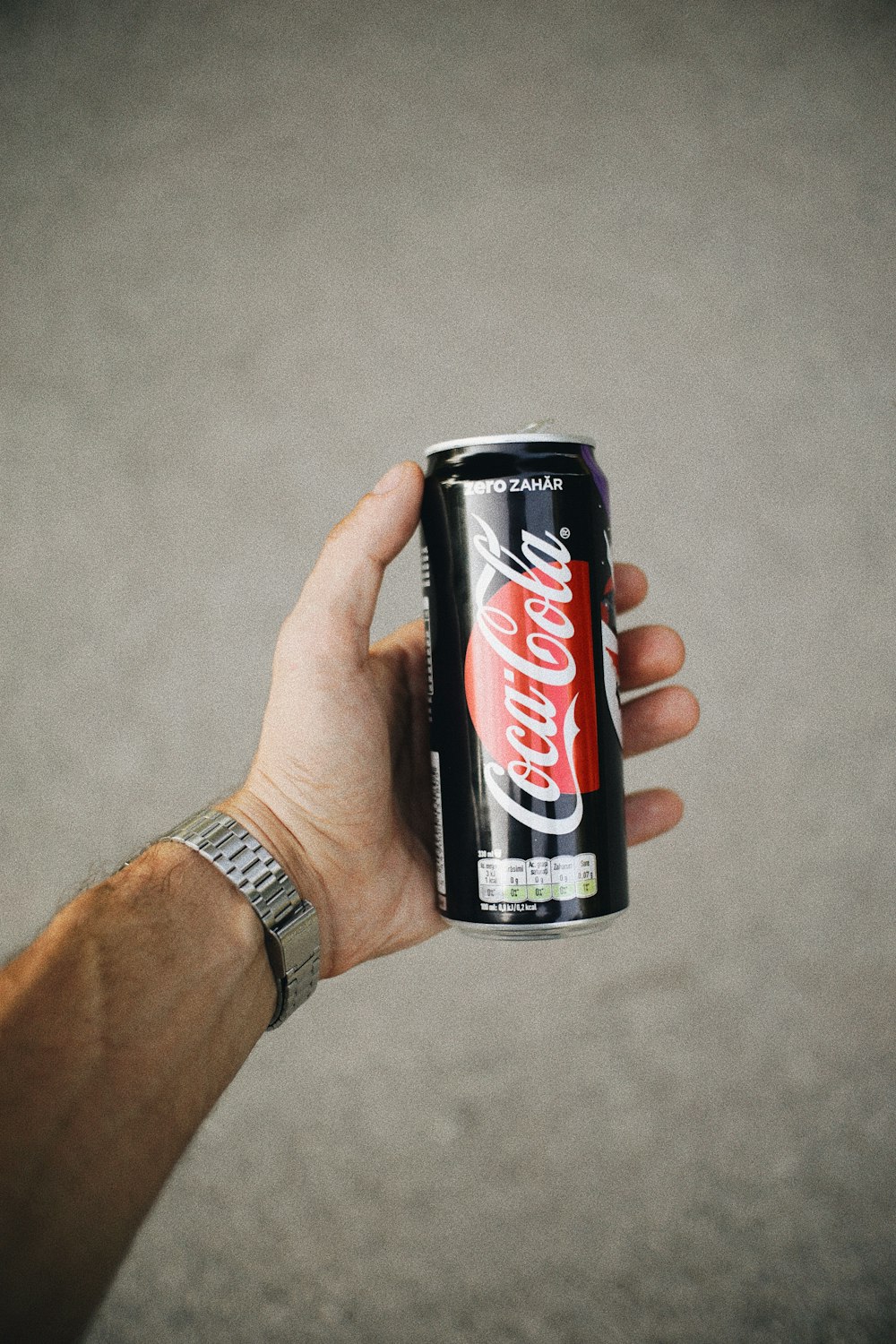 a hand holding a can of coca cola