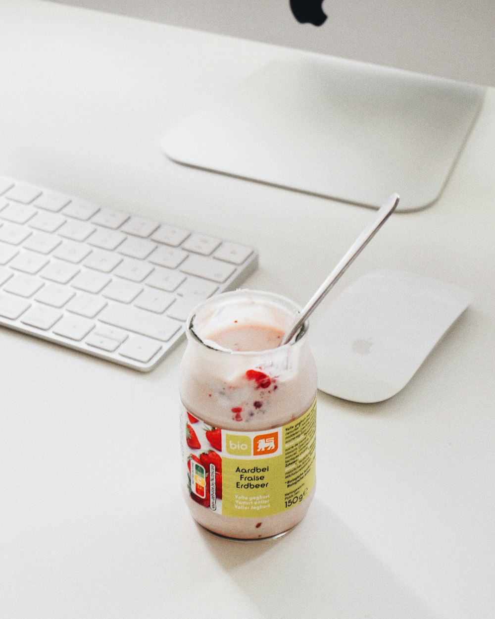 a jar of yogurt sitting on a desk next to a keyboard