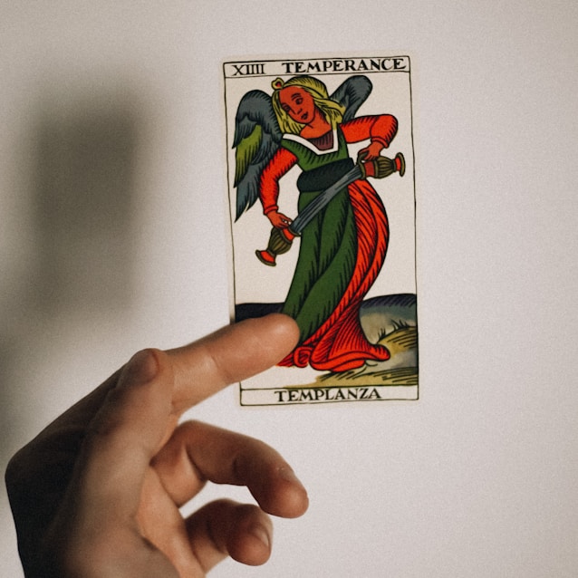 a person holding up a card with a devil on it