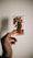 A hand holds a tarot card depicting an angelic figure with green and red robes. The card bears the title 'Temperance' with the number XIV at the top. The background is plain with a soft shadow cast by the hand and card.