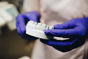 Hand holding a unique personalized mold with the brand logo visible in the background.
