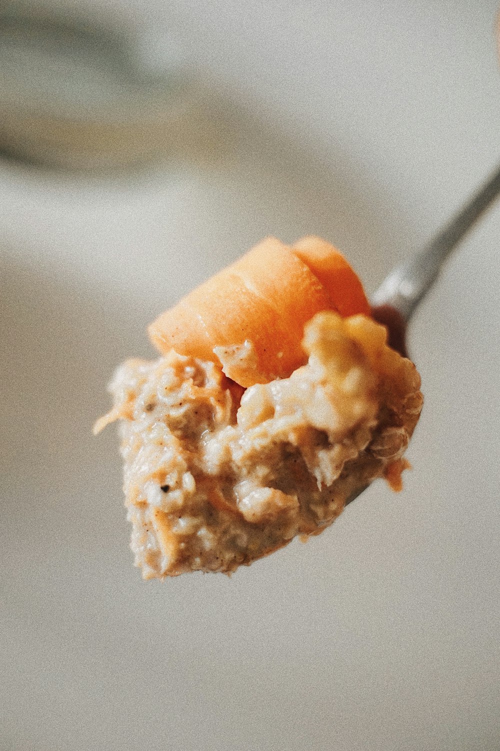 una cuchara llena de avena y zanahorias