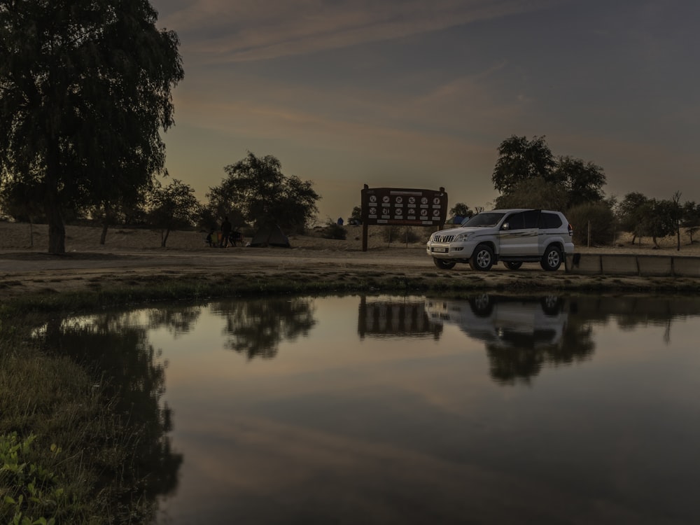 a white van parked next to a body of water