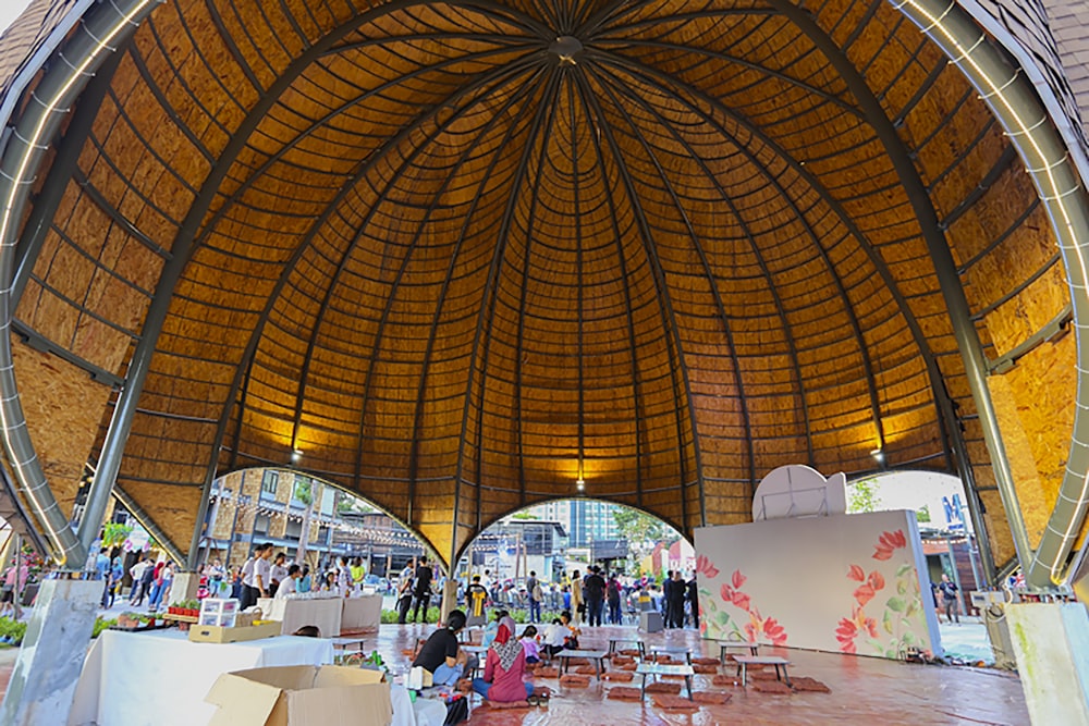 a group of people standing under a wooden roof