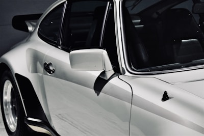 Side view of a sleek car with a mirror-like finish after detailing.