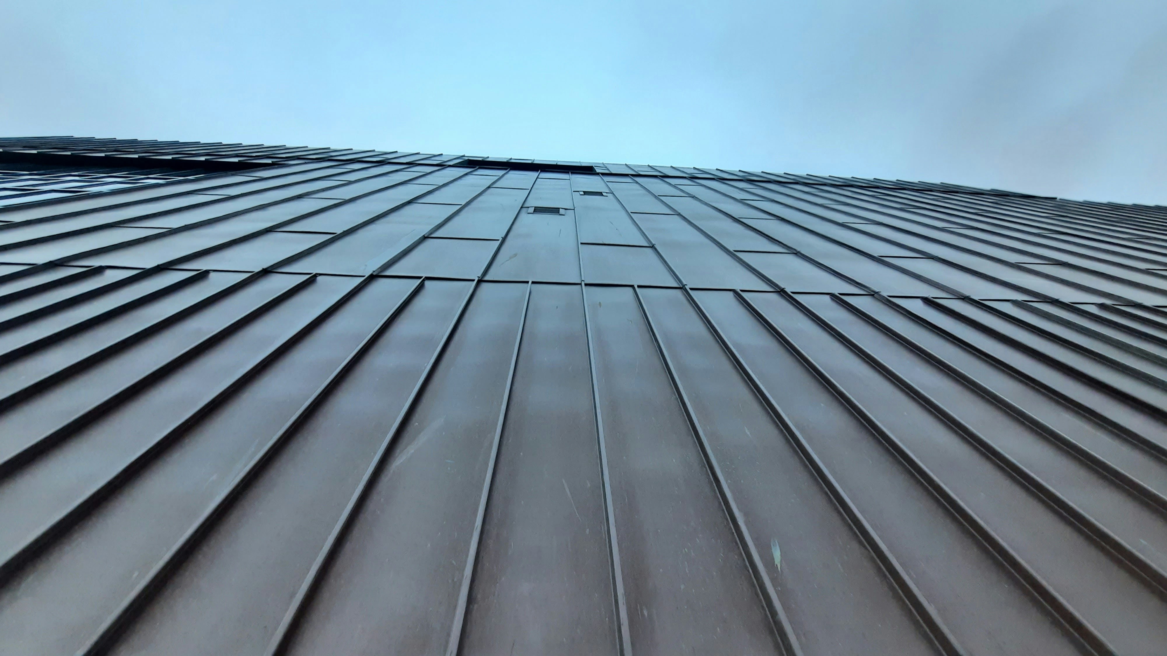 professional metal roof installation showing flashing and underlayment details - how long does a metal roof last