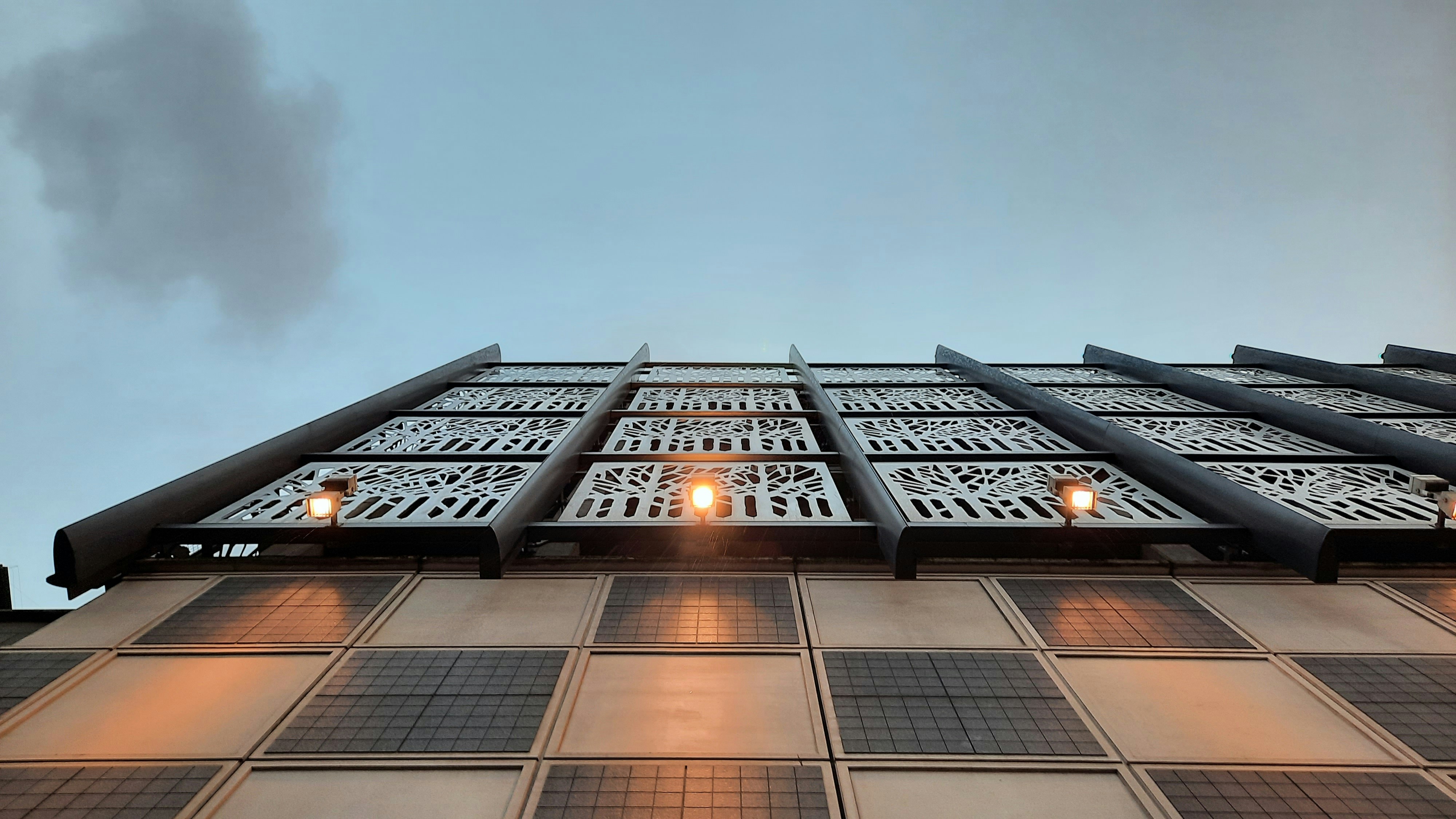 a tall building with lots of windows and a sky background