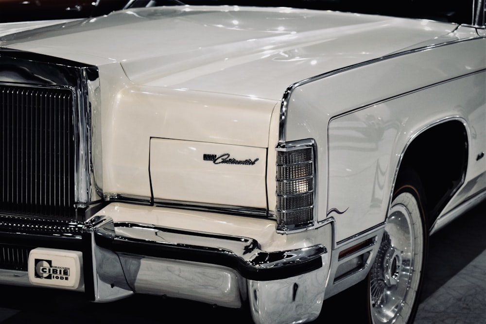 a white car parked in a garage next to another car