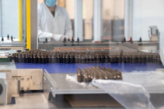 a factory with a conveyor belt and a worker in the background