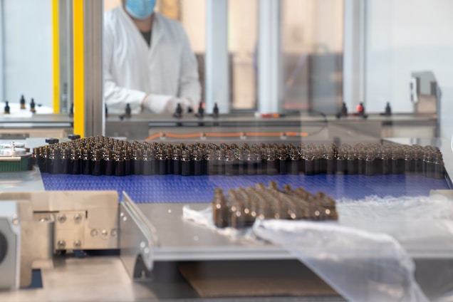 a factory with a conveyor belt and a worker in the background