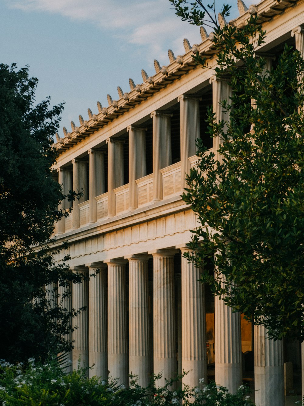 a building with columns and a clock on the front of it