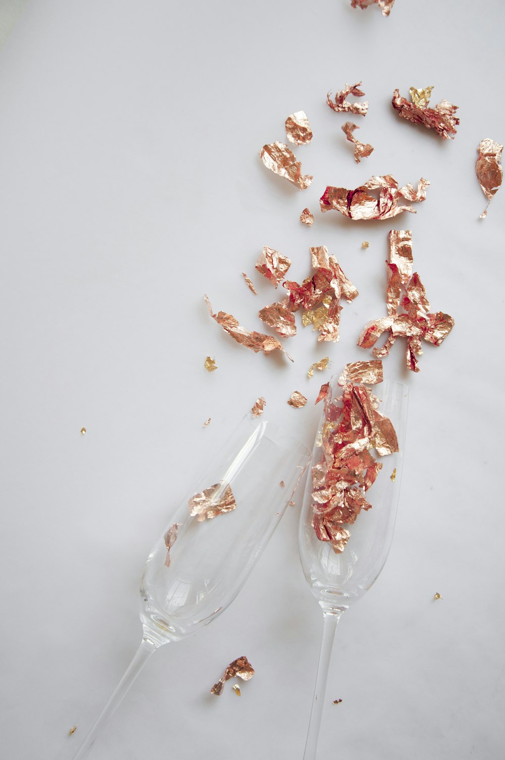 a couple of wine glasses filled with gold confetti