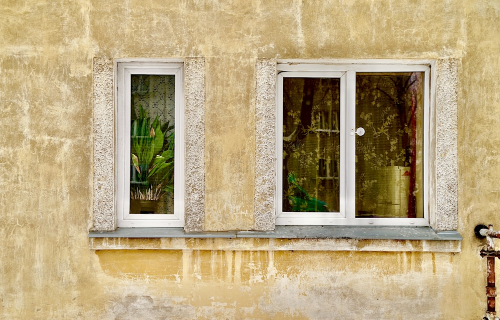 a yellow building with three windows and a bike parked in front of it