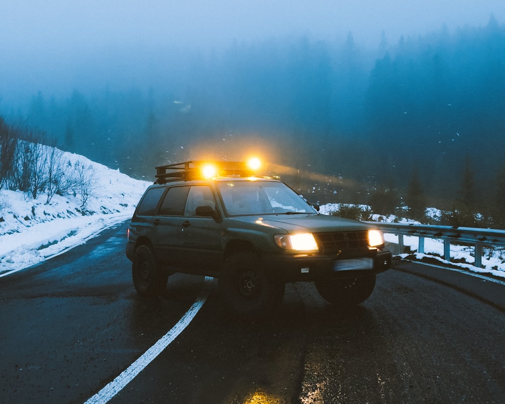 a police car driving down a road in the snow