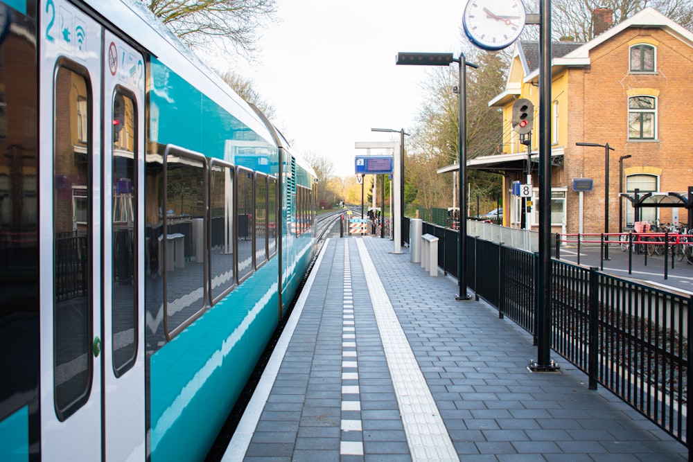 a blue and white train stopped at a train station