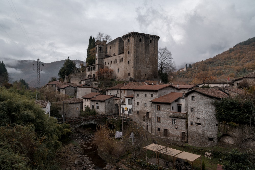 an old castle sits on a hill above a river