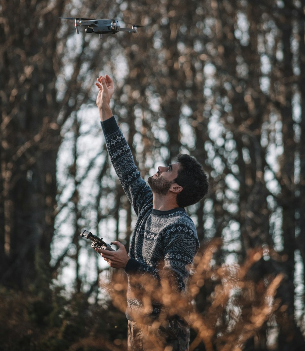 a man holding a remote control airplane in the air