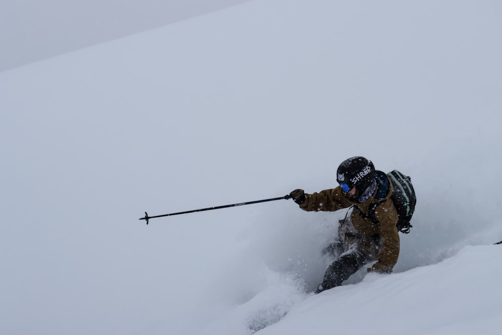 Un homme dévalant une pente enneigée à skis