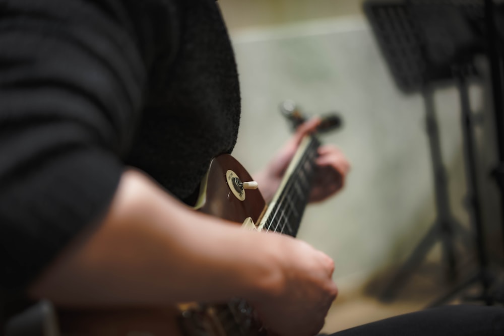 a person playing a guitar in a recording studio