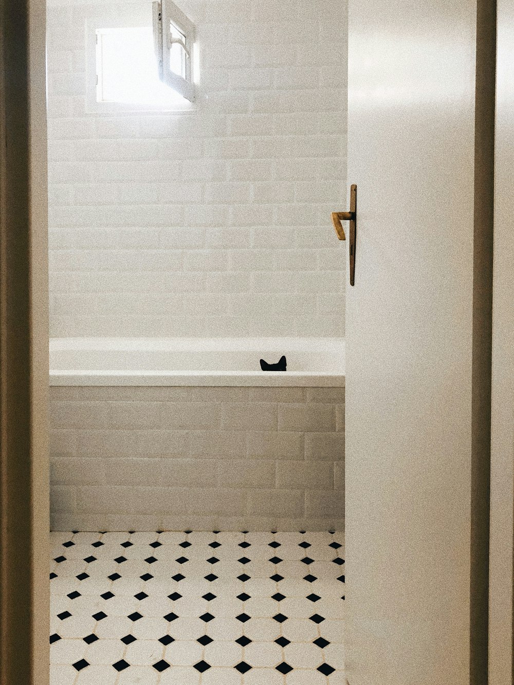 a bathroom with a black and white tile floor