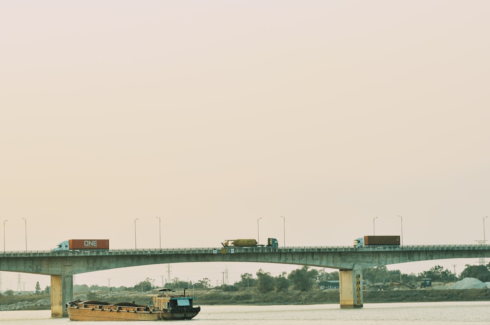 a boat traveling down a river under a bridge